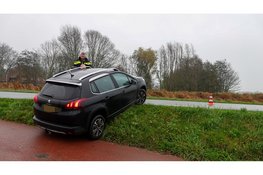 Man rijdt achteruit van dijk en bungelt over de rand in Heerhugowaard