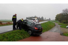 Man rijdt achteruit van dijk en bungelt over de rand in Heerhugowaard