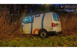 Bedrijfsbus ramt verkeerspaal en belandt in het water