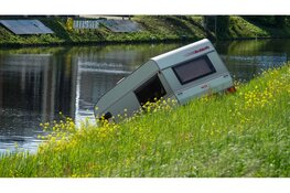 Auto verliest caravan op N242 en belandt in het water